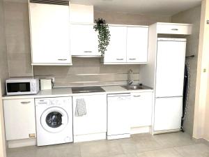 a kitchen with white cabinets and a washing machine at Nest Silence in Valencia
