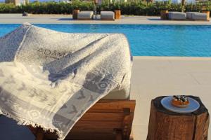 a table with a blanket on it next to a pool at Adama Mykonos Boutique Hotel in Mikonos