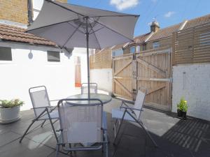 patio con tavolo, sedie e ombrellone di Host & Stay - Herbert Road a Ramsgate