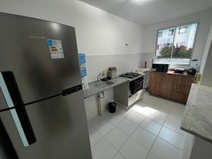 eine Küche mit einem Kühlschrank aus Edelstahl und einer Spüle in der Unterkunft Apartamentos da Thay in Campina Grande