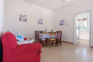 comedor con mesa y silla roja en Punta Prosciutto Sea View Facing the Sea With Air Conditioning, Parking And Wi-Fi, en Torre Lapillo