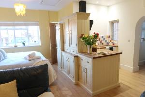 a bedroom with a bed and a counter with flowers on it at Bourne House, private modern apartment near Rugby & Lutterworth 