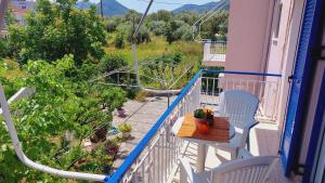 a balcony with a table and chairs and a roller coaster at Emilios Eleni studios in Nydri