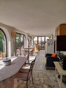 a kitchen and living room with a table and chairs at Villa Casa das Palmeiras in Charneca