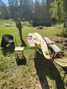 drewniana ławka i krzesło na polu w obiekcie Baltās Raganiņas pirts w mieście Sabile