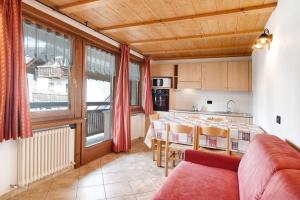 een woonkamer met een tafel en een keuken bij Baita Truzz appartamento Valle in Livigno