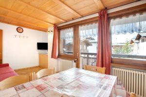 een eetkamer met een tafel en een raam bij Baita Truzz appartamento Valle in Livigno