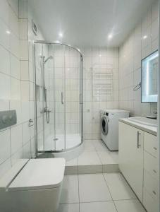 uma casa de banho com um chuveiro, um WC e um lavatório. em Residential complex Parkland em Kiev