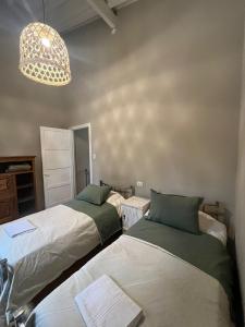 a bedroom with two beds and a light fixture at Casa Campo - Altamira in Campo Los Andes +7 photos