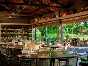 a dining room with tables and chairs and windows at Lavandeira Douro Nature & Wellness in Baião