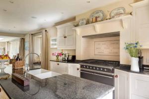 a kitchen with white cabinets and a stove top oven at Vine House in Salcombe