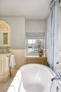 a bathroom with a large tub and a window at Vine House in Salcombe