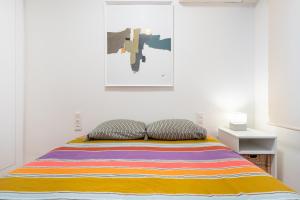 a bedroom with a bed with a colorful striped blanket at Plaza del Teatro in Málaga
