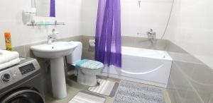 a bathroom with a sink and a toilet and a bath tub at Comfortable apartments complex at Nova Garden near Disney Land in Tashkent
