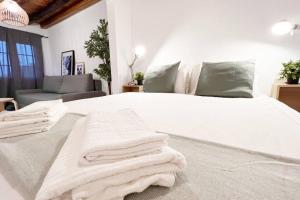 Un dormitorio con una cama blanca con toallas. en Ventana al Cielo de Cudillero by Batuecas, en Cudillero