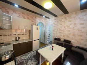 a kitchen with a table and a white refrigerator at Comfortable apartments complex at Nova Garden near Disney Land in Tashkent