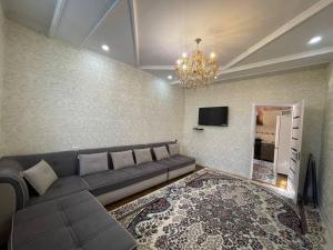 a living room with a couch and a tv at Comfortable apartments complex at Nova Garden near Disney Land in Tashkent
