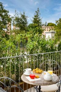 a table with food and drinks on a balcony at Villa Gremì - Monforte d'Alba in Monforte dʼAlba