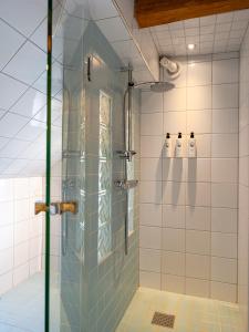 uma casa de banho com chuveiro e 2 garrafas em Villa Vega em Trosa