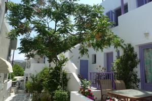 un árbol frente a un edificio blanco con una mesa en Vourkari house, en Ioulida