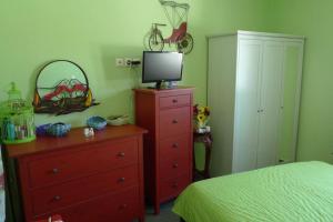 a bedroom with a bed and a dresser with a television on it at Vourkari house in Ioulis