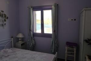 1 dormitorio con cama y ventana en Vourkari house, en Ioulida