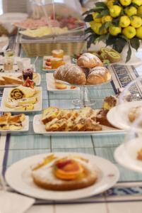 a table topped with plates of pastries and other foods at Hotel Luxor in Rimini