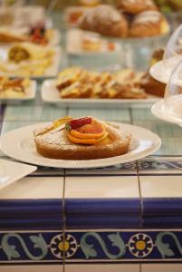 un plato con un trozo de pan con rodajas de naranja en él en Hotel Luxor, en Rímini