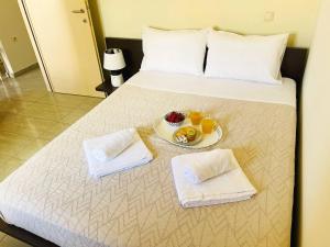 a bed with a plate of fruit on it at Cozy Nest - 2min To Beach, 6min Walk To Old Town in Chania