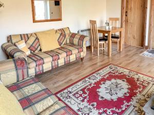 ein Wohnzimmer mit einem Sofa und einem Tisch in der Unterkunft Hillcrest Cottage in Broxa