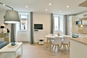 kuchnia i salon ze stołem i krzesłami w obiekcie L'Amanyn - Appartement proche plage w mieście Dinard