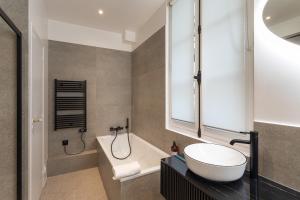 雷恩的住宿－Le Goya - Appartement 4 chambres centre ville de Rennes，带浴缸、水槽和浴缸的浴室