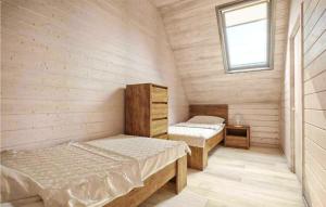 ein kleines Zimmer mit 2 Betten und einem Fenster in der Unterkunft Nice Home In Darlwko With Kitchen in Darłówko