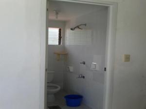 ein weißes Bad mit einem WC und einer Dusche in der Unterkunft Sea Apartment-Pinca in Manila