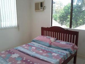 ein kleines Bett in einem Zimmer mit Fenster in der Unterkunft Sea Apartment-Pinca in Manila