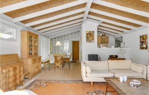 a living room with a white couch and a table at Holiday Home Ringgårdsvej in Hornbæk