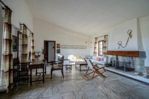 a living room with a fireplace and a table and chairs at Sonia Rustic Mansion - 5bd 30 Sec Walk To Beach in Agioi Apostoli
