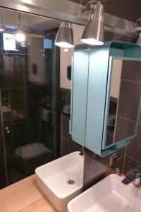 uma casa de banho com um lavatório, um espelho e um chuveiro em We Collect Umbrellas em Split