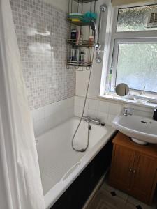 a bathroom with a bath tub and a sink at Axel Rooms 3 in Manchester