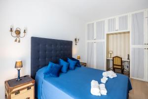 ein Schlafzimmer mit einem blauen Bett und Handtüchern darauf in der Unterkunft [BOCCONI] Elegante Appartamento con WIFI in Mailand