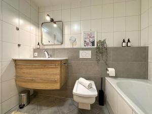 une salle de bain avec un lavabo, des toilettes et une baignoire dans l'établissement Appartio - modern - luxuriös - Netflix - Flughafennähe - 55 qm, à Leura 16 autres photos
