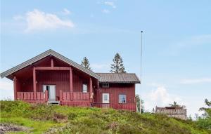 czerwony dom na szczycie wzgórza w obiekcie 5 Bedroom Cozy Home In Lifjell w mieście Lifjell