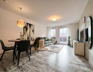 - un salon avec une table à manger et un canapé dans l'établissement Appartio - modern - luxuriös - Netflix - Flughafennähe - 55 qm, à Leura