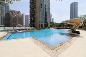 a large swimming pool in a city with tall buildings at Burj Vista 08 3BR Burj & Fountain View in Dubai