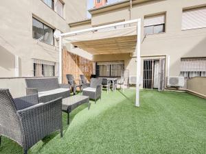 an outdoor patio with chairs and an umbrella at Apartamento para 4 con terraza privada en el centro in Girona