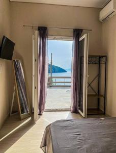 Dormitorio con puerta con vistas al océano en Poseidon’s Bayview, en Kitriaí