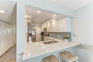 a kitchen with white cabinets and a sink at Resting Beach Place managed by Beach Retreats in Holmes Beach