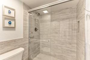 a bathroom with a shower with a glass door at Resting Beach Place managed by Beach Retreats in Holmes Beach +28 photos