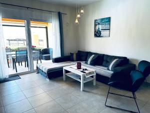 una sala de estar con un sofá y una mesa en To Steki 1min From Beach 2bd 1ba, en Panormos Rethymno