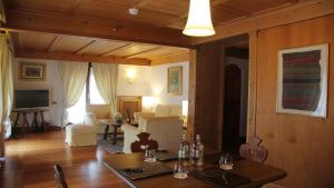 a dining room with a table and a living room at Hotel Bellevue Suites & Spa in Cortina dʼAmpezzo